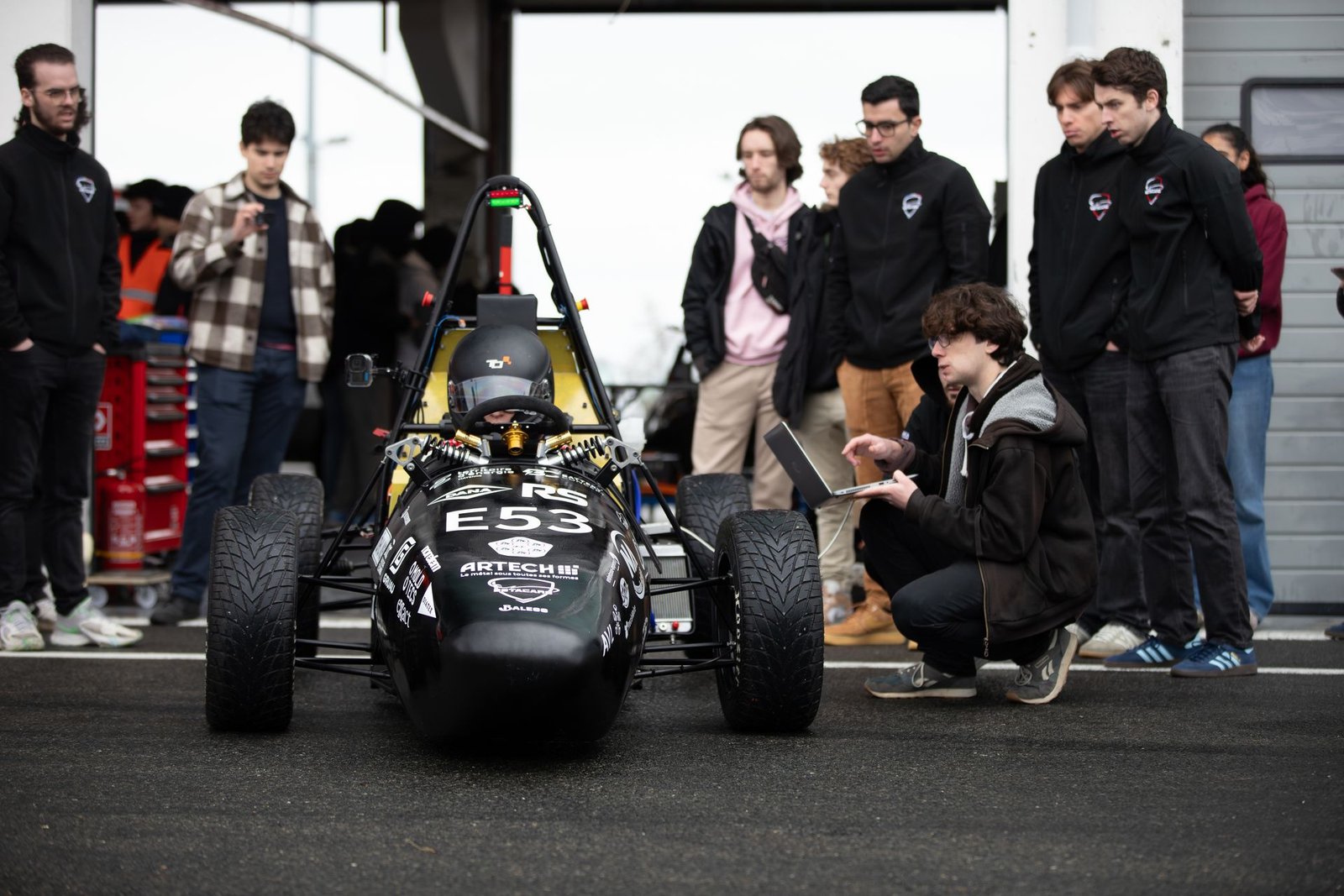 Étudiants autour d’une monoplace de course